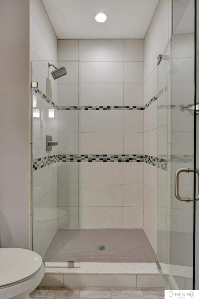 bathroom featuring toilet and an enclosed shower