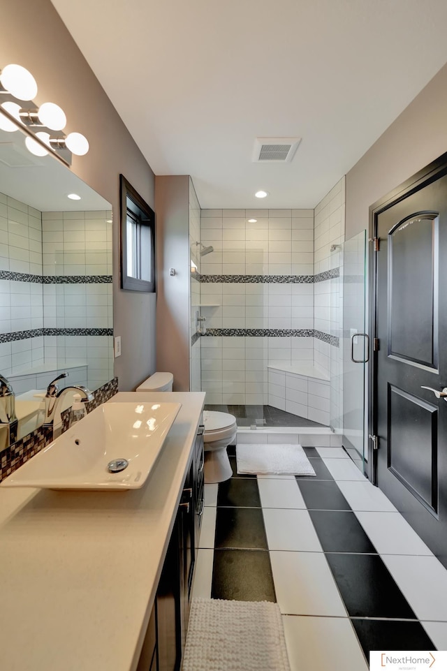 bathroom with tile patterned flooring, vanity, toilet, and a shower with shower door