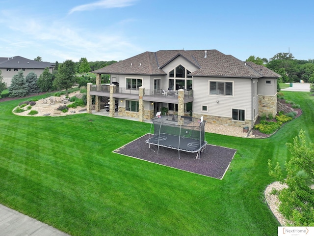 rear view of house featuring a lawn, a patio area, and a balcony