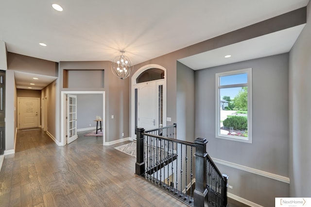 hall with hardwood / wood-style flooring and a chandelier