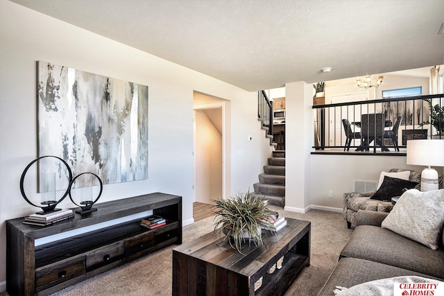 carpeted living room featuring a chandelier and a textured ceiling