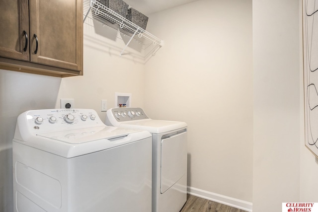 laundry area featuring washer and dryer, dark hardwood / wood-style floors, and cabinets