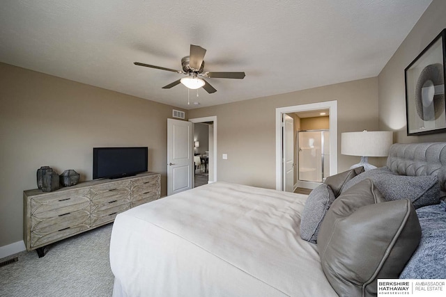 bedroom with carpet flooring, a textured ceiling, connected bathroom, and ceiling fan