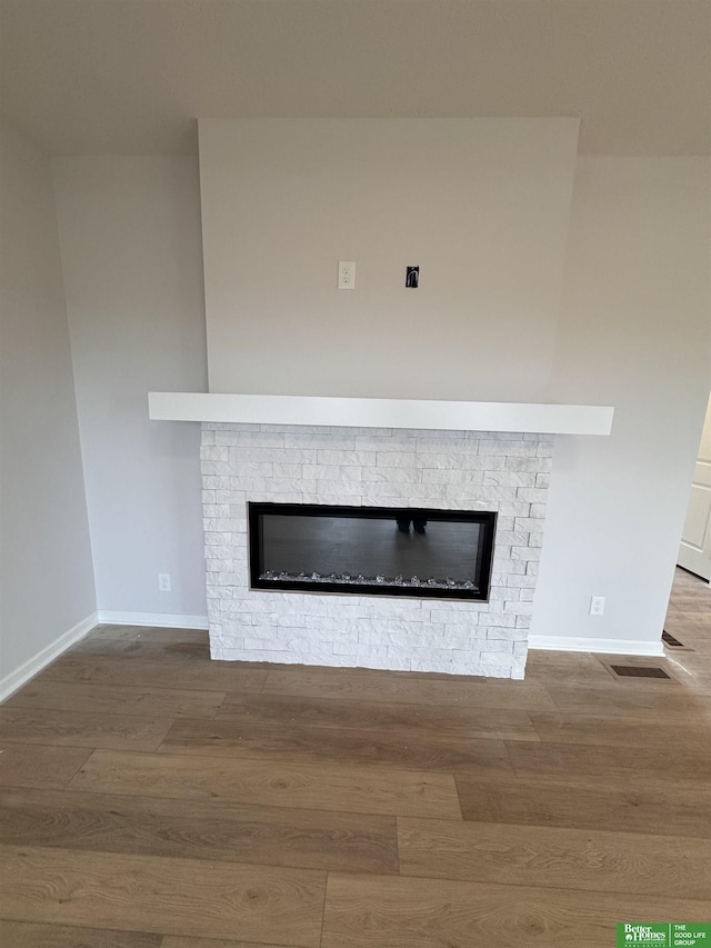 room details featuring hardwood / wood-style flooring and a stone fireplace