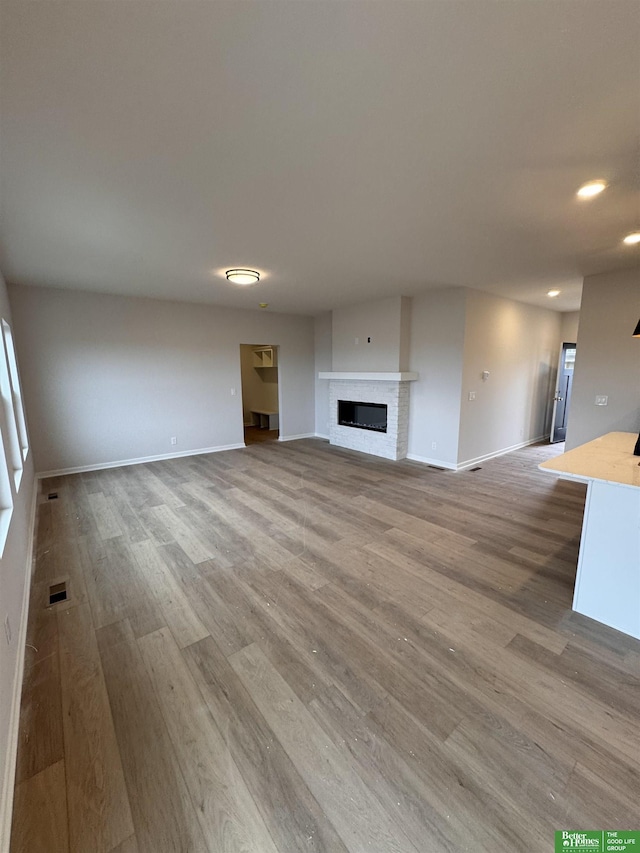 unfurnished living room with a fireplace and wood-type flooring