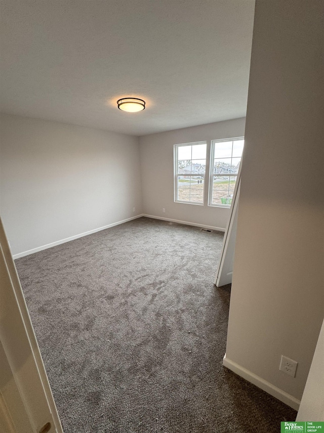 unfurnished room with dark carpet