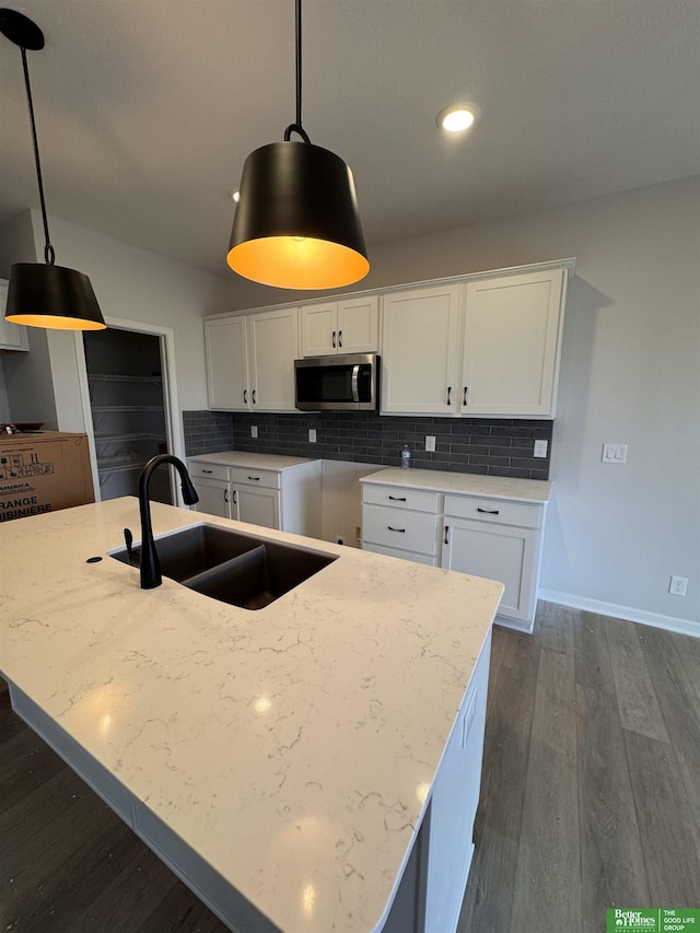 kitchen with white cabinets, decorative light fixtures, and sink