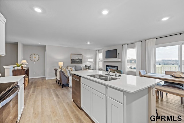 kitchen with dishwasher, a kitchen island with sink, white cabinets, black range with electric stovetop, and sink