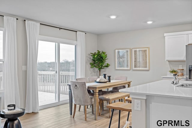 dining space featuring light wood-type flooring and sink