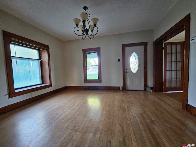 foyer featuring a chandelier, hardwood / wood-style flooring, and a textured ceiling