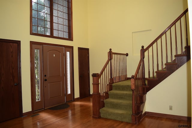 entryway with a high ceiling and dark hardwood / wood-style floors