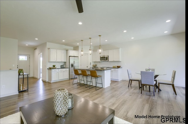 living area featuring recessed lighting, baseboards, and light wood finished floors