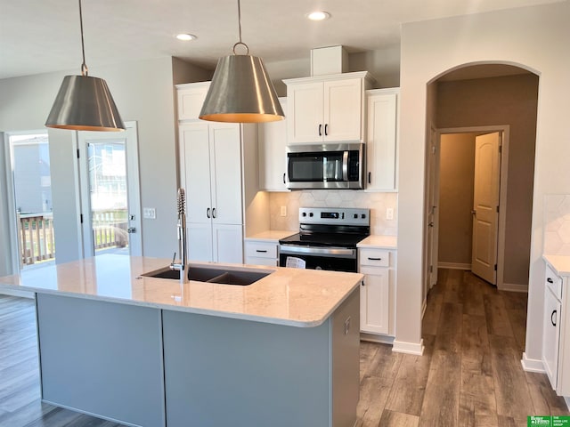 kitchen featuring stainless steel appliances, white cabinetry, and hanging light fixtures