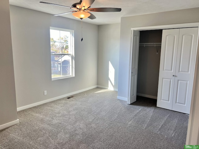 unfurnished bedroom featuring carpet floors, a closet, baseboards, and a ceiling fan