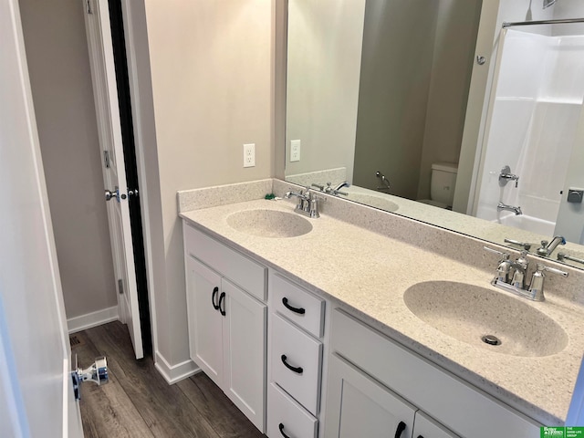 full bathroom featuring hardwood / wood-style flooring, vanity, toilet, and tub / shower combination