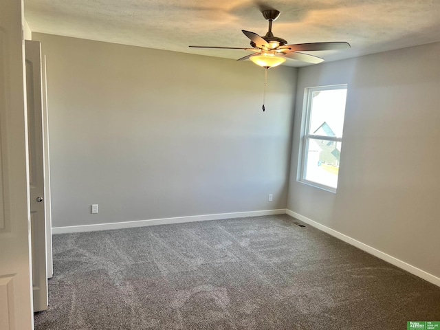 carpeted empty room featuring ceiling fan and baseboards