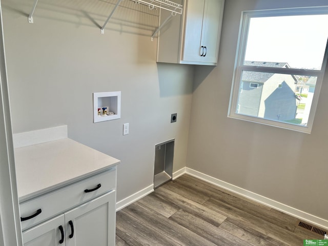 laundry area with washer hookup, electric dryer hookup, baseboards, dark wood finished floors, and cabinet space