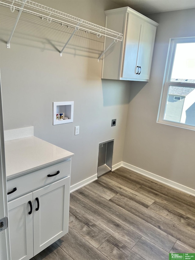 clothes washing area featuring washer hookup, electric dryer hookup, cabinet space, baseboards, and dark wood-style flooring