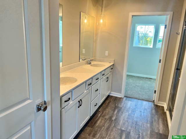 bathroom with hardwood / wood-style flooring, vanity, and a shower