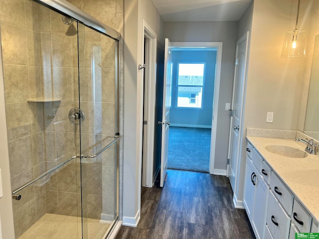 bathroom featuring wood-type flooring, vanity, and an enclosed shower