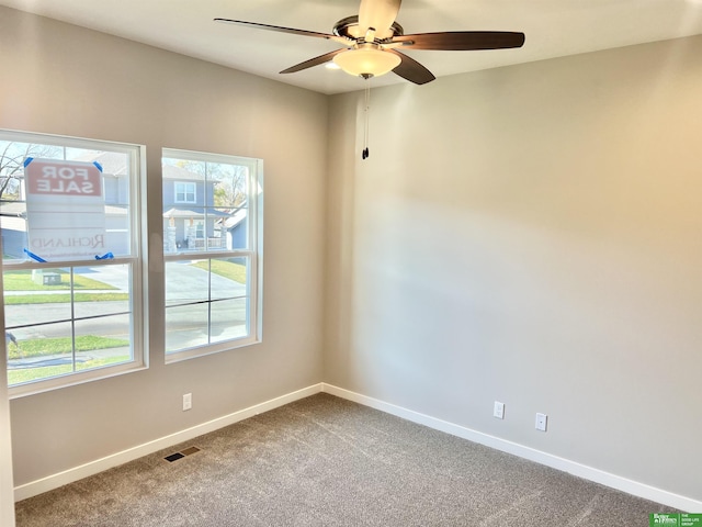 carpeted empty room with baseboards and ceiling fan