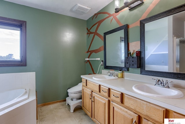 bathroom with vanity, a relaxing tiled tub, tile patterned flooring, and toilet