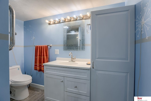 bathroom with a textured ceiling, vanity, toilet, and hardwood / wood-style flooring