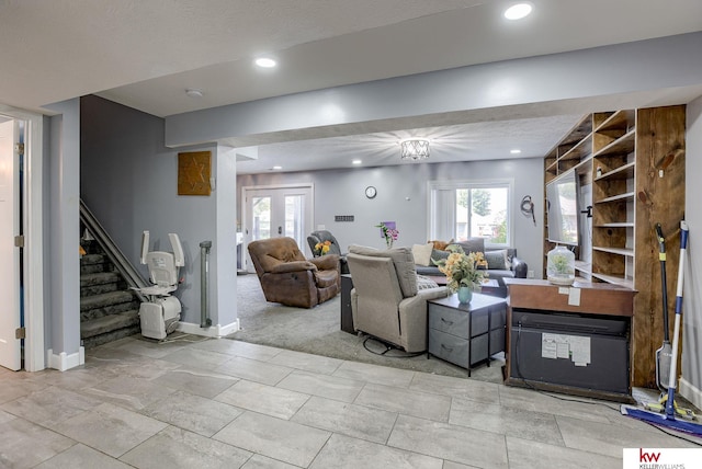 living room featuring light carpet, a textured ceiling, and french doors