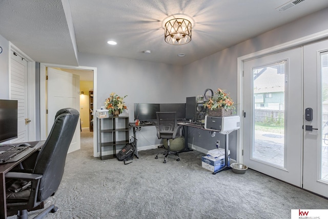 carpeted office featuring a textured ceiling