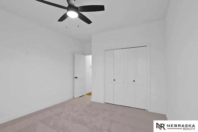 unfurnished bedroom featuring ceiling fan, a closet, and light colored carpet