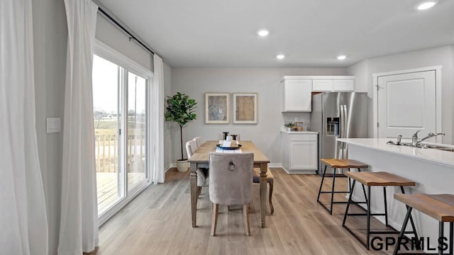 dining space with sink and light hardwood / wood-style flooring