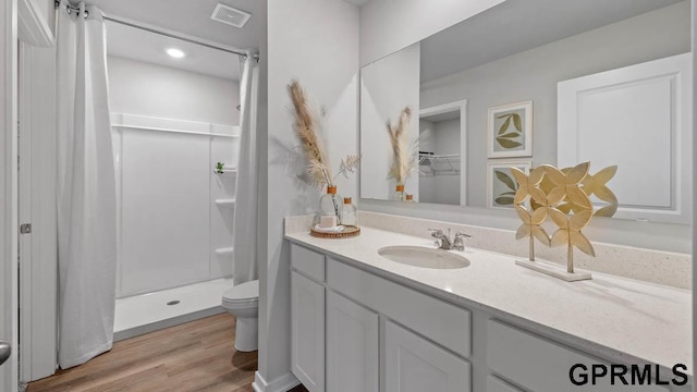 bathroom with vanity, toilet, curtained shower, and hardwood / wood-style floors