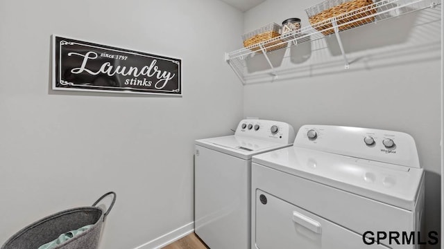 clothes washing area featuring independent washer and dryer and wood-type flooring