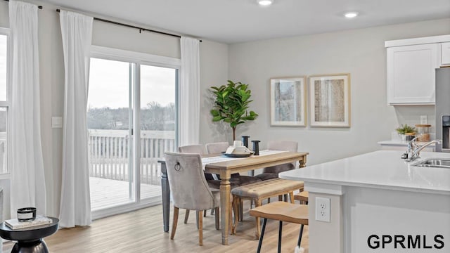 dining area featuring sink and light wood-type flooring