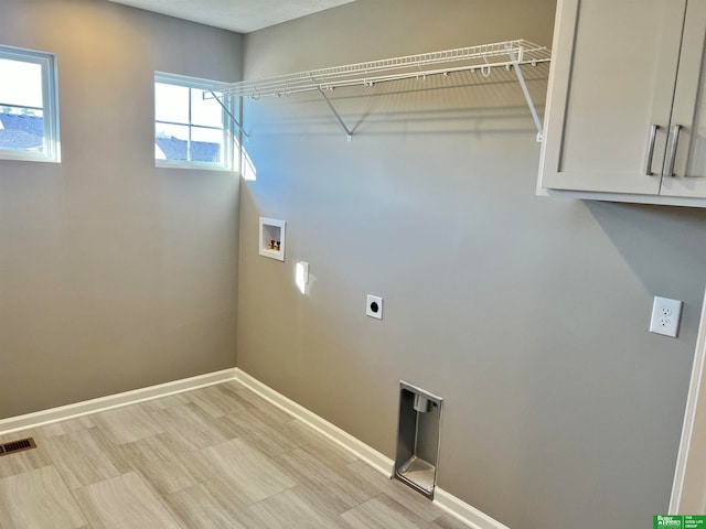 washroom featuring electric dryer hookup, hookup for a washing machine, and cabinets