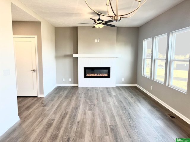 unfurnished living room with wood-type flooring and ceiling fan