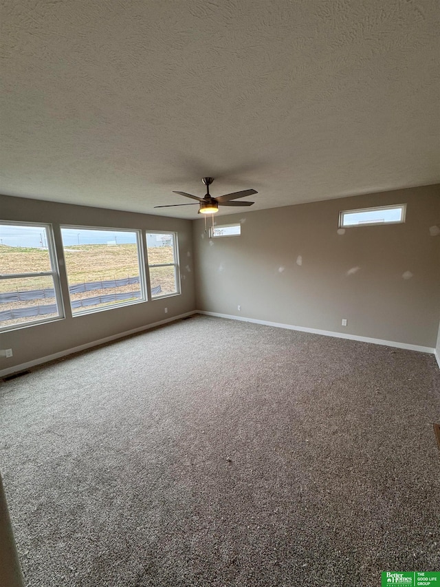 unfurnished room featuring ceiling fan, carpet floors, and a textured ceiling