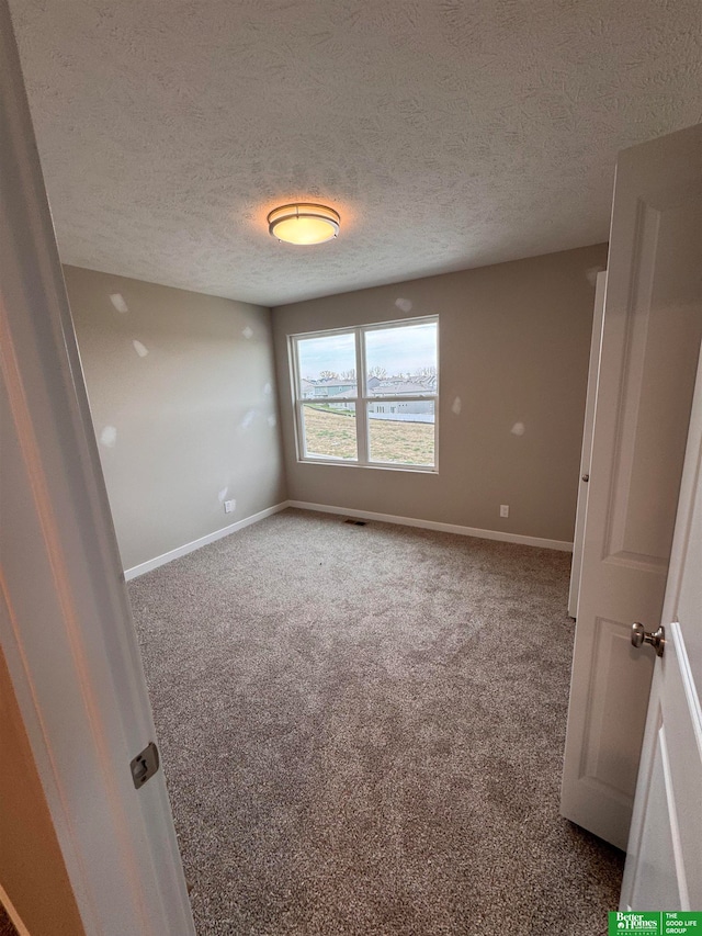 empty room featuring carpet flooring and a textured ceiling