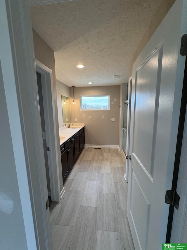 bathroom with vanity and a textured ceiling