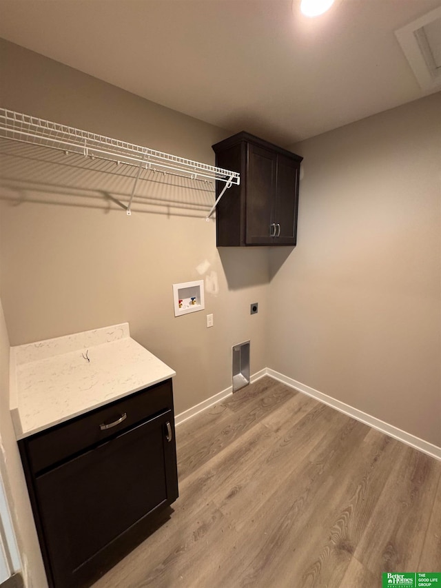 laundry room with cabinets, washer hookup, light hardwood / wood-style flooring, and electric dryer hookup