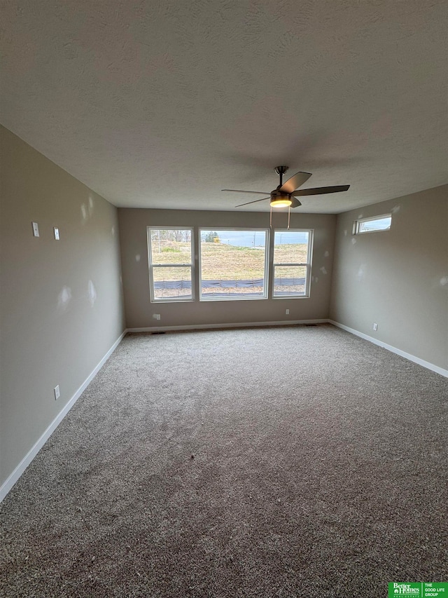 carpeted empty room featuring ceiling fan and a textured ceiling