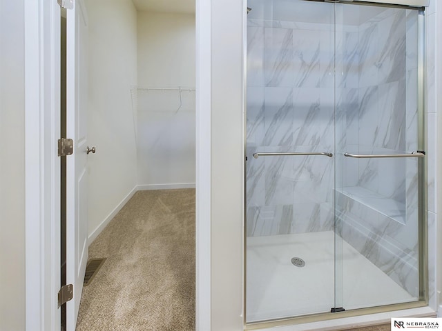 bathroom with a shower with door