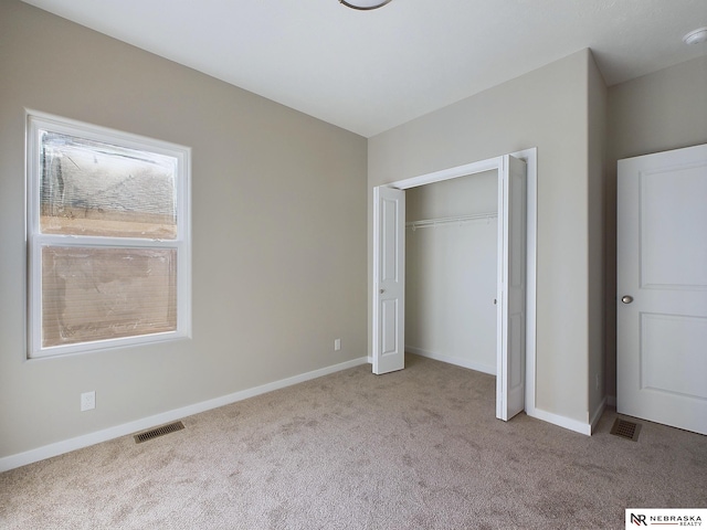 unfurnished bedroom with light carpet and a closet