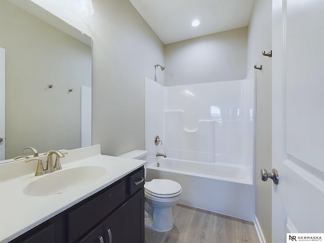 full bathroom with vanity,  shower combination, hardwood / wood-style flooring, and toilet