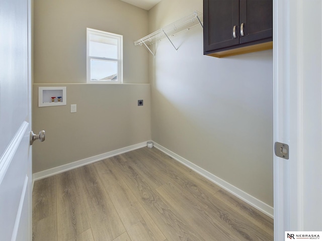 clothes washing area featuring cabinets, hookup for a washing machine, light hardwood / wood-style flooring, and hookup for an electric dryer