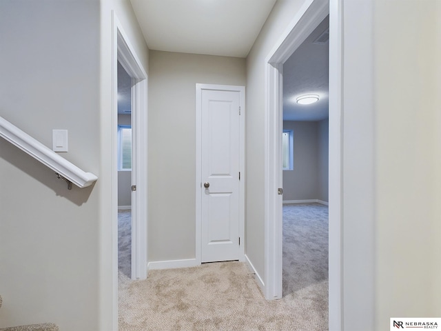 corridor featuring light colored carpet