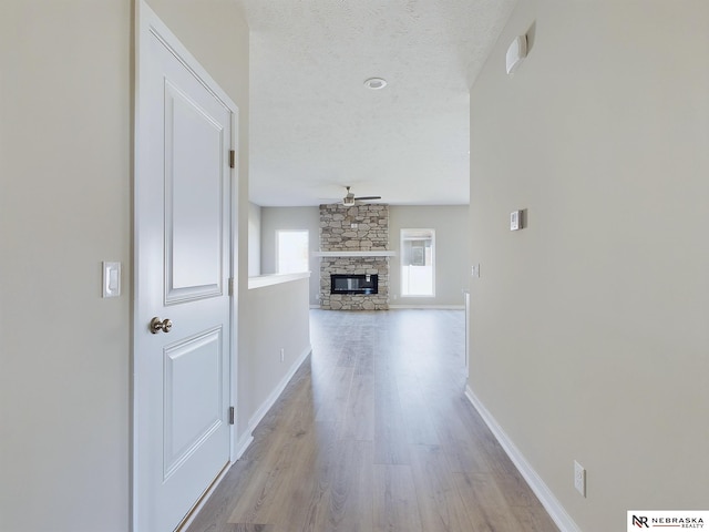 corridor featuring light hardwood / wood-style flooring and a textured ceiling