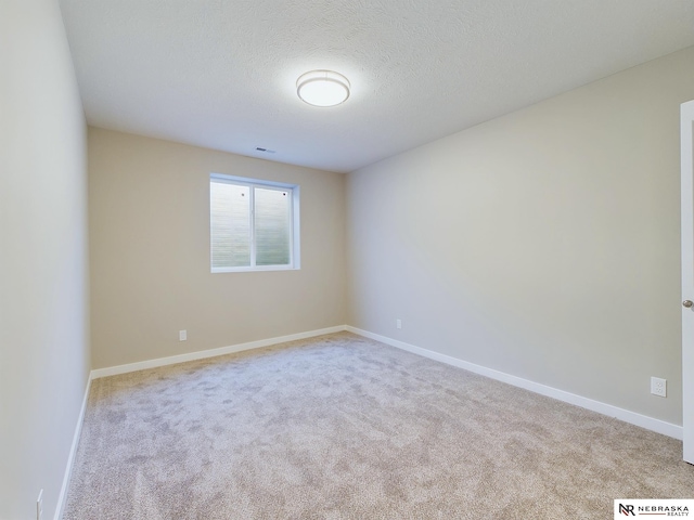 unfurnished room with light carpet and a textured ceiling