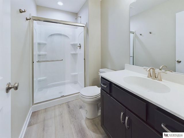 bathroom featuring hardwood / wood-style floors, vanity, toilet, and an enclosed shower