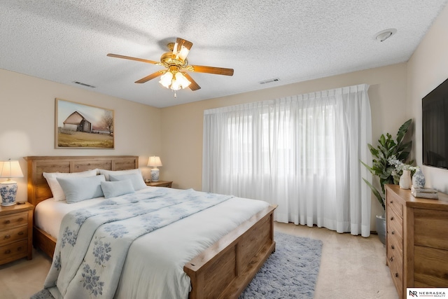 carpeted bedroom featuring a textured ceiling and ceiling fan